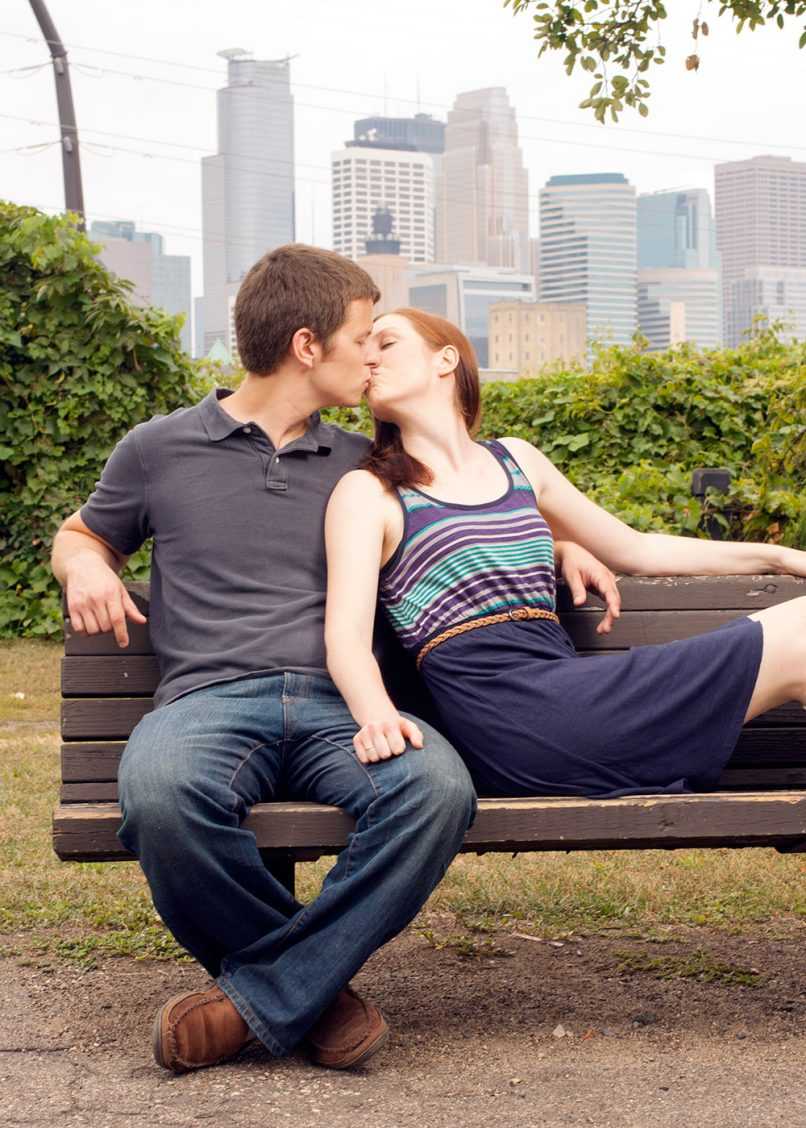 Happy couple kissing on park bench