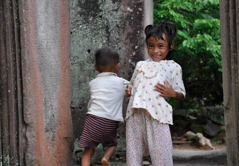 Children running around ruins of Angkor Wat in Cambodia