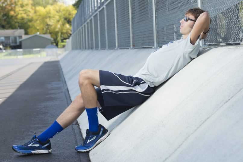 Senior boy relaxing at high school track