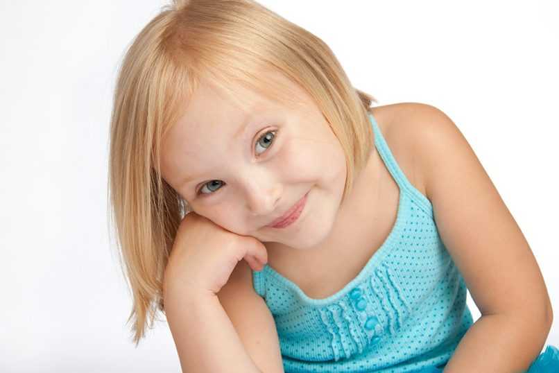 Little girl smiling in front of white background