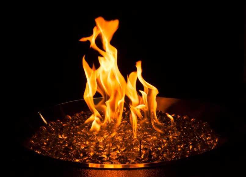 Closeup of fire pan of gas fire table with a flame