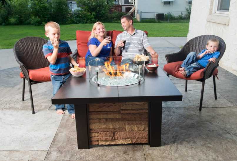 Family relaxing in front of a gas fire table