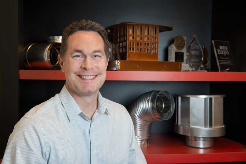 Business owner sitting in front of venting products