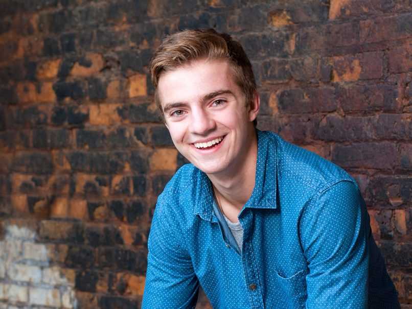 Senior portrait of boy in front of brick background