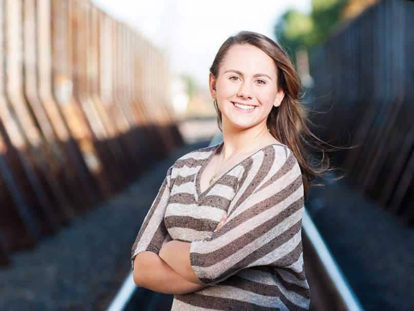 Senior portrait of girl in front of train track